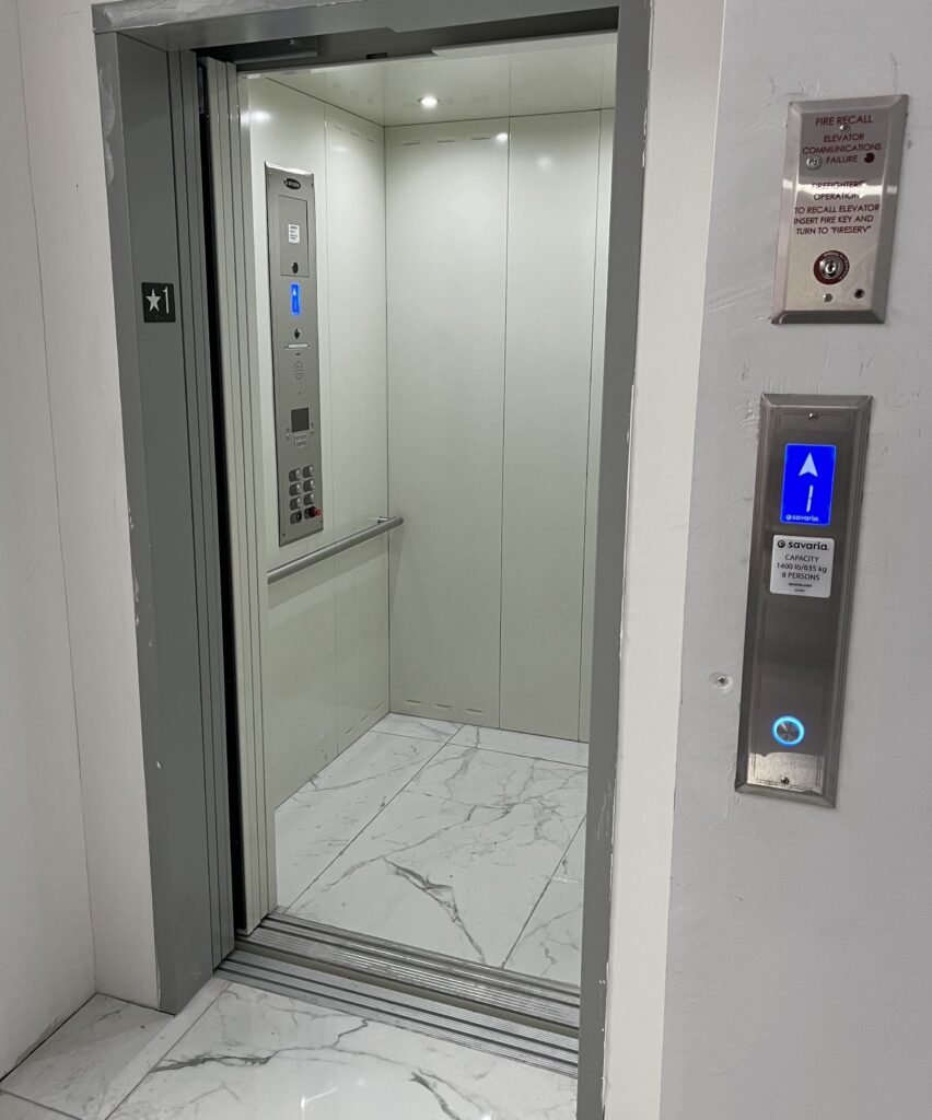 A metallic commercial elevator waiting to move someone vertically